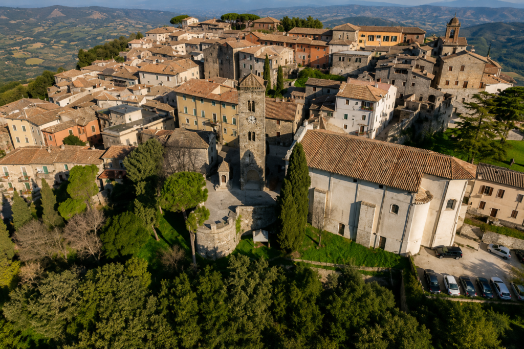 Veduta panoramica di Fara in Sabina, borgo della Valle del Farfa, con centro storico medievale, Abbazia di Farfa, campanile, oliveti e colline sabine.