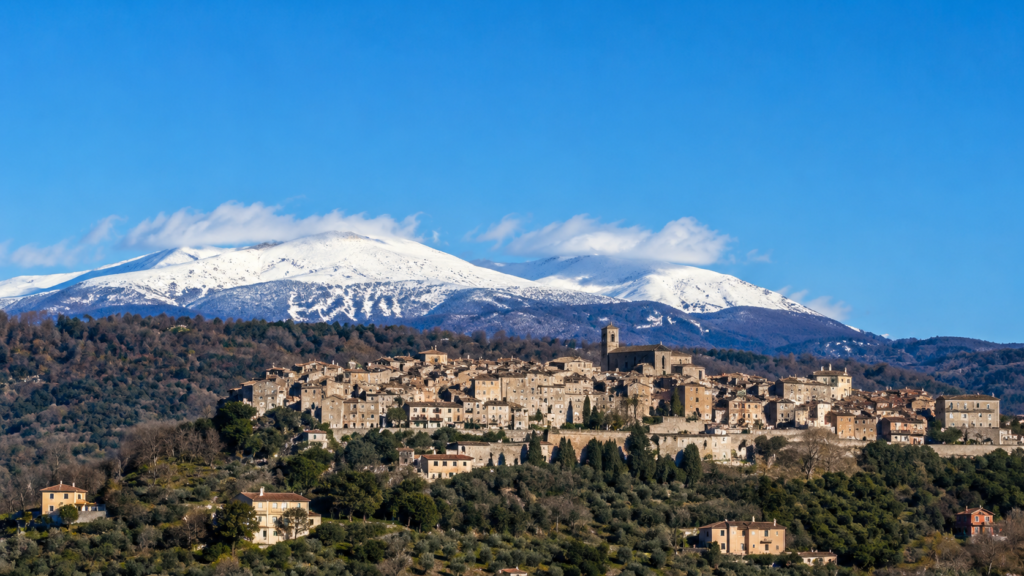 Veduta panoramica di Monteleone Sabino, borgo dell’Alta Sabina, con case storiche, colline verdi e montagne innevate sullo sfondo