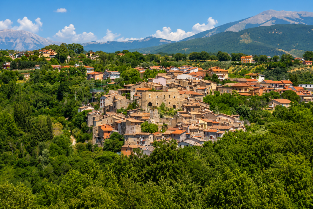 Veduta panoramica di Poggio Nativo, borgo della Valle del Farfa, con centro storico, Castello Savelli, oliveti, boschi e montagne della Sabina.