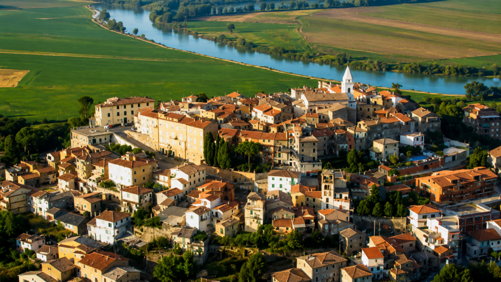 Veduta panoramica di Ponzano Romano, borgo della Sabina Tiberina, con centro storico, campanile, tetti in cotto e fiume Tevere sullo sfondo.