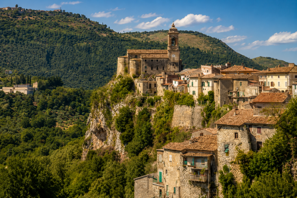 Veduta panoramica di Toffia, borgo della Valle del Farfa, con centro storico medievale, Chiesa di Santa Maria Nova, campanile, case in pietra e colline sabine.