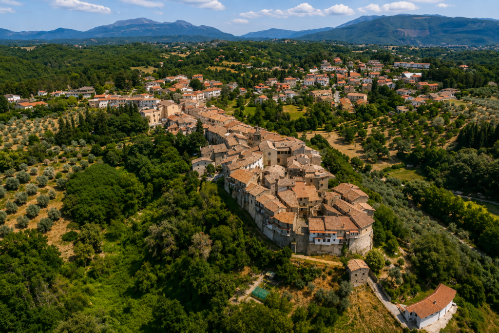 Veduta panoramica di Torricella in Sabina, borgo dell’Alta Sabina, con case storiche, campanile, boschi e colline verdi.